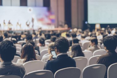 Konferans salonu veya Seminer Toplantı, iş ve eğitim yatırım kavramı hakkında sahnede hoparlörler dinleme seyirci arkadan görünüş