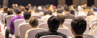 Afiş kapak sayfasından konferans salonu veya Seminer Toplantı, iş ve eğitim yatırım kavramı hakkında sahnede hoparlörler dinleme seyirci arkadan görünüş