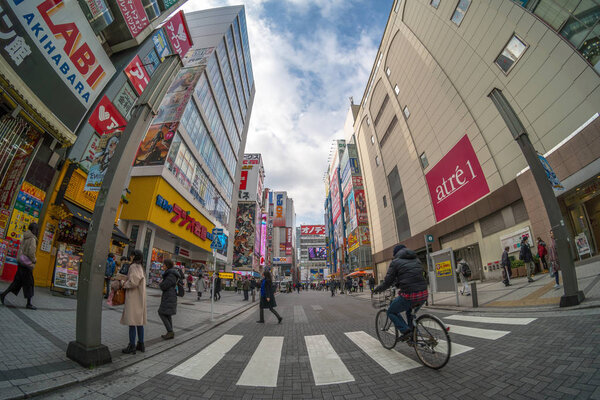 TOKYO, JAPAN - FEB 2019 : pedestrians crowd undefined people walking overpass the street intersection cross-walk in Akihabara on Febuary 13, 2019 in Tokyo,Japan.culture and electric town shopping area