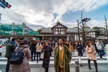 Tokyo, Japonya - Şubat 2019 : 16 Şubat 2019 tarihinde Harajuku istasyonunda sokak çapraz yürüyüşüne gelen ve yürüyen tanımsız insanlar ve turist kalabalığı, Japon kültürü ve alışveriş alanı konsepti