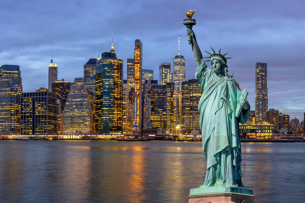 The Statue of Liberty over the Scene of New york Cityscape with Brooklyn Bridge beside the east river at the twilight time, Architecture and building with tourist concept, United States of America, USA
