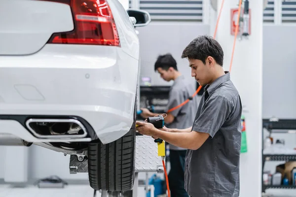 Azjatycki Mechanicy Sprawdzanie Koła Samochodu Centrum Serwisowym Dla Salonie — Zdjęcie stockowe