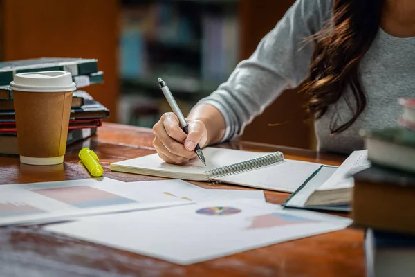 Primer plano Asiático joven Estudiante escritura a mano tarea en la biblioteca de —  Fotos de Stock