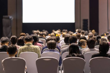 Konferans salonu veya Seminer Toplantı, iş ve eğitim yatırım kavramı hakkında sahnede hoparlörler dinleme seyirci arkadan görünüş