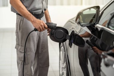 Closeup asya Teknisyen el bakım için servis merkezinde elektrikli araba veya Ev şarj, Çevre dostu alternatif enerji konsepti