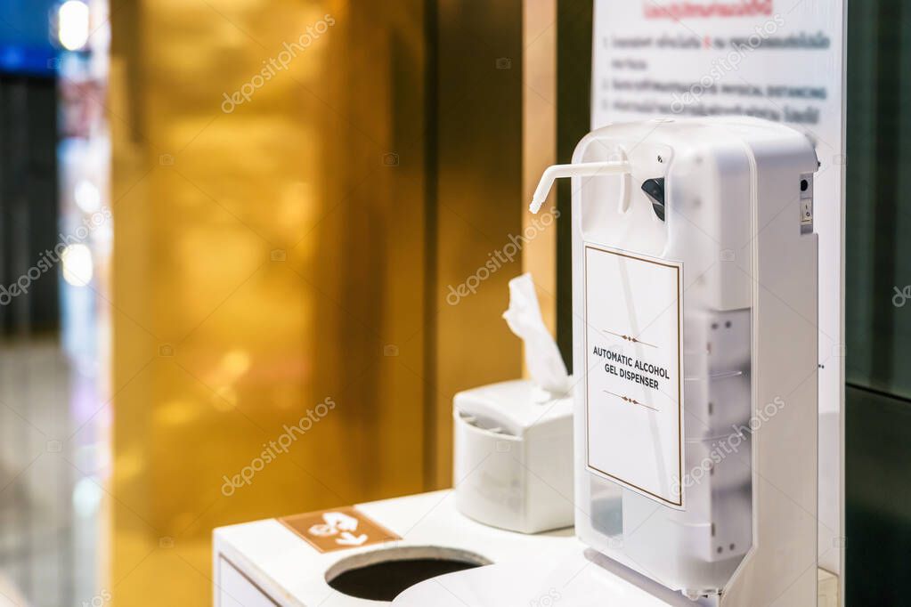 Automatic alcohol gel dispenser on the waste bin in front of elevator in department store after Relief measures Covid19 Outbreak, Coronavirus pandemic, Social distancing and new normal concept