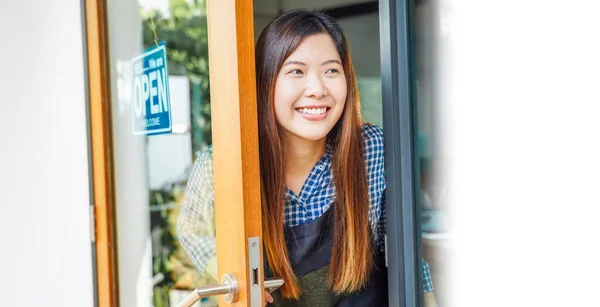 기사보기 아시아 여성이 커피숍에 들어가는 고객을 환영하기 사인을 — 스톡 사진