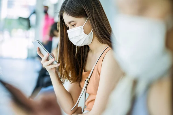 Giovane Passeggera Asiatica Con Maschera Chirurgica Utilizzando Telefono Cellulare Social — Foto Stock