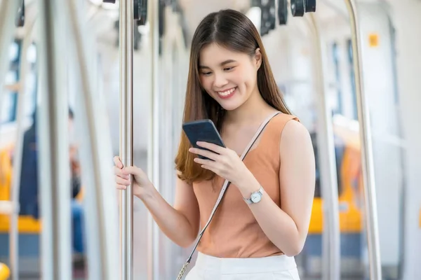 Joven Pasajera Asiática Usando Teléfono Móvil Inteligente Mirando Hacia Fuera —  Fotos de Stock