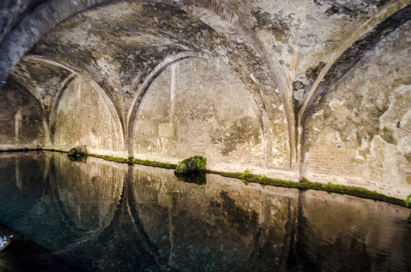 Множественные арки, сходящиеся над водой с отражением
