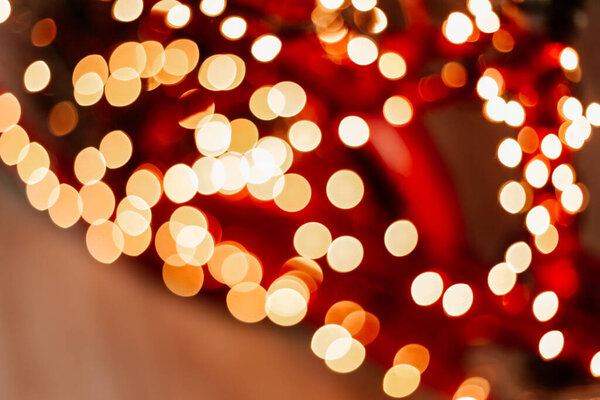 Blurred picture of christmas tree with lights and spruce branch. Defocused new year background with space for text