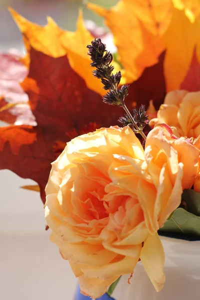 Autumn flower composition with roses and maple leaves