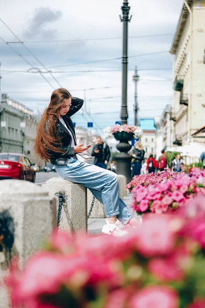 Genç bir kadın büyük bir şehrin işlek caddesinde oturup selfie çekiyor.. — Stok fotoğraf