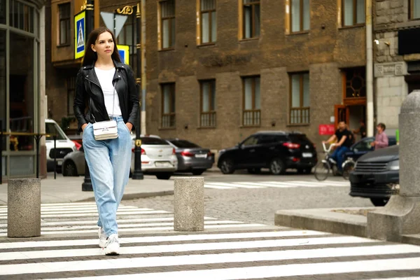 旧市街の道を横断する若い女性. — ストック写真