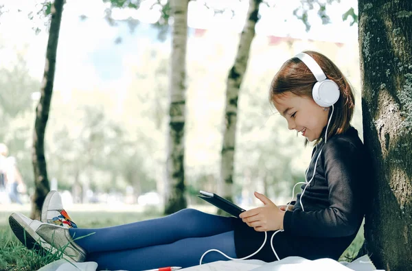 Parkta dijital tablet kullanan mutlu kız