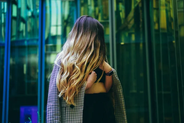 Πίσω όψη της νεαρής γυναίκας με τα όμορφα ξανθά μακριά μαλλιά σε κίνηση — Φωτογραφία Αρχείου