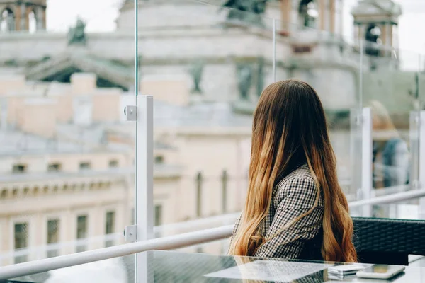 Rückansicht der jungen Frau mit schönen blonden langen Haaren auf der Terrasse eines Restaurants — Stockfoto
