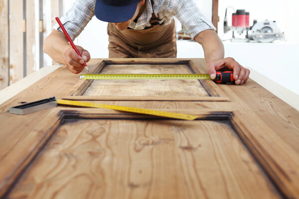 carpenter work the wood, measuring a wooden vintage door