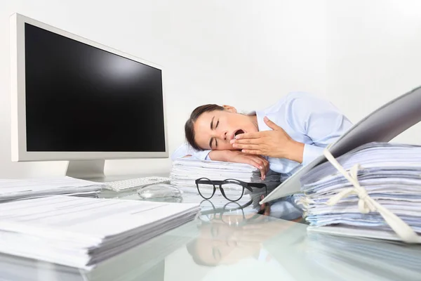困倦的企业妇女打呵欠 工作在办公桌前的空显示器与一堆文件 过度劳累和睡眠剥夺概念 — 图库照片