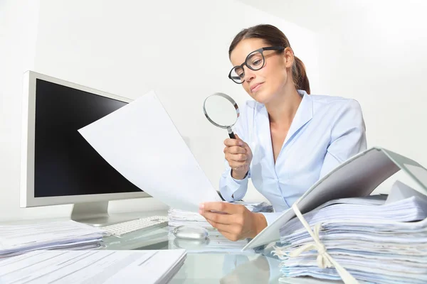 business woman in office check documents and contracts with magnifying glass sitting at the desk isolated on white background