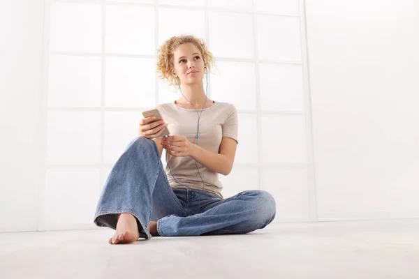 Sitting Young Woman Earphones Cell Phone Curly Hair Dressed Jeans — Stock Photo, Image