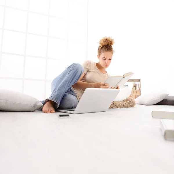 Mujer Joven Con Computadora Leyendo Libro Sentada Suelo Sala Estar — Foto de Stock