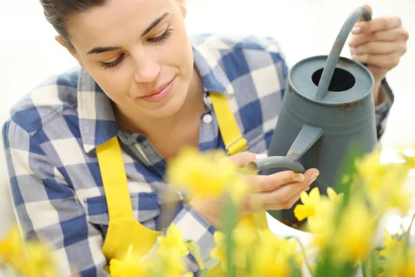 Женщина поливает цветы в саду, весенняя концепция — стоковое фото