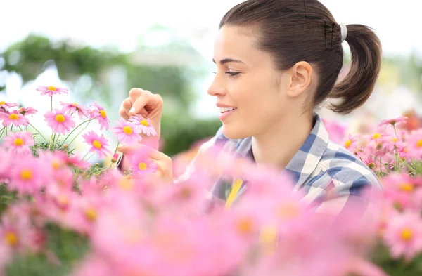Koncepcja wiosna, uśmiechnięta kobieta w ogrodzie kwiaty stokrotki — Zdjęcie stockowe