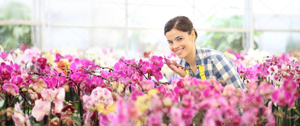 spring concept, smiling woman in the garden of orchids flowers