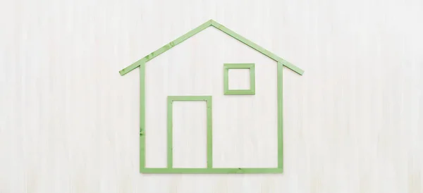 Дерев'яна зелена форма будинку ізольована на дерев'яному білому фоні, сірий — стокове фото