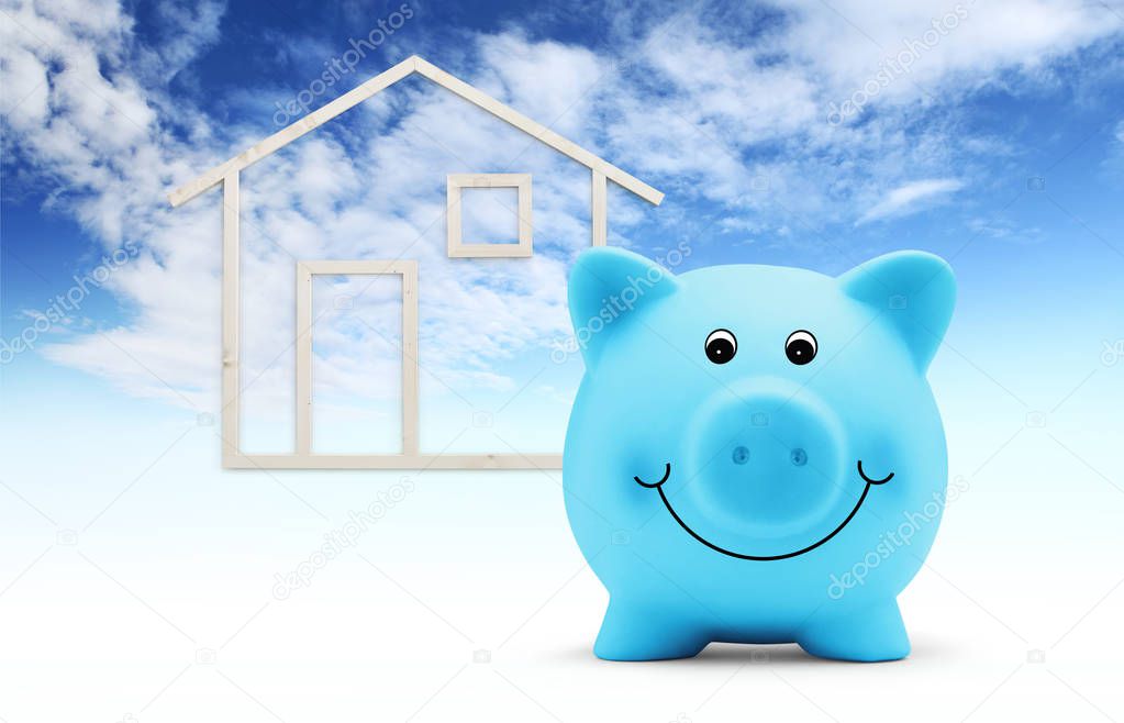 piggy bank with wood house shape isolated on blue sky background