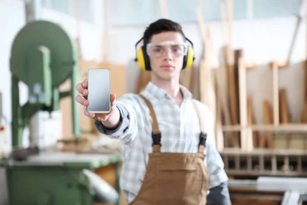 carpenter man show the mobile phone isolated on carpentry backgr