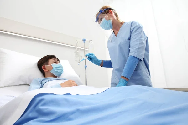 Sjuksköterska Med Termometer Mäter Feber Patientbarn Sjukhussäng Bär Skyddande Visir — Stockfoto