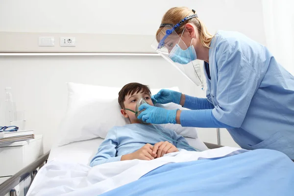 Sjuksköterska Sätter Syrgasmask Patientens Barn Sjukhussäng Bär Skyddande Visir Mask — Stockfoto