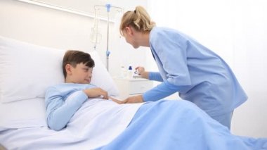 Çocuk hastane yatağında yatıyordu. Aşı iğnesi için hemşirenin iğnesinden korkmuş ve dehşete düşmüştü.