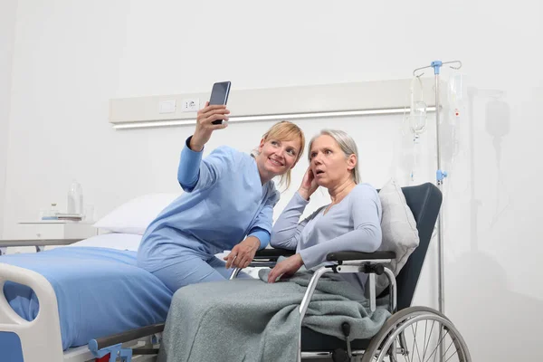 Sjuksköterska Hjälper Med Mobiltelefon För Att Kontakta Den Äldre Damens — Stockfoto