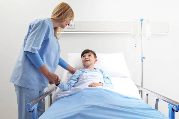 Liten Pojke Liggande Sjukhussäng Med Leende Sjuksköterska Handen — Stockfoto
