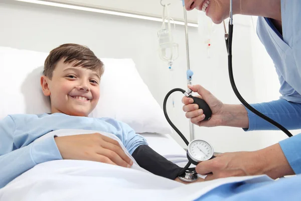 Szczęśliwe Dziecko Leżące Łóżku Pokoju Szpitalnym Pielęgniarka Mierzące Jego Ciśnienie — Zdjęcie stockowe