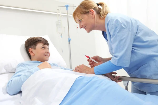 Niño Feliz Acostado Cama Habitación Del Hospital Mirando Enfermera Hace —  Fotos de Stock