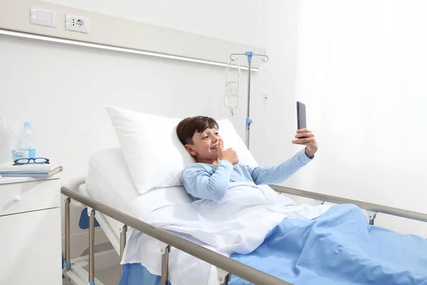 Happy Child Lying Bed Alone Hospital Room Taking Selfie Smartphone — Stock Photo, Image