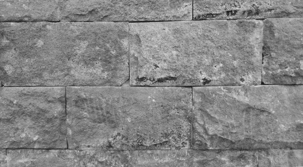 Marble wall with abstract texture. There appears to be grass trying to grow between the rocks. Images suitable for use as wallpaper, background, or graphic resources