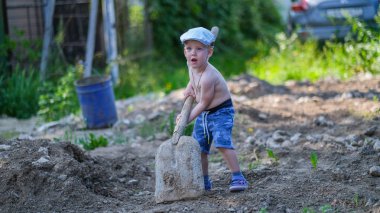 Sevimli küçük çocuk yazlık bir kürek kazır