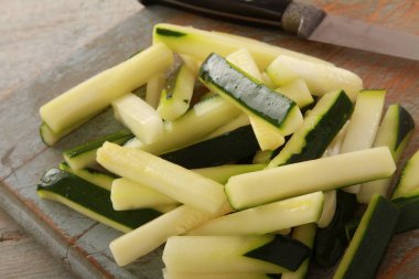 preparing courgette batons on the table clipart
