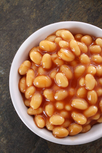 baked beans in tomato sauce in white  dish