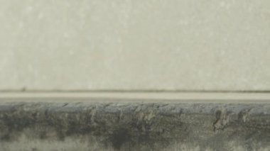 Ağır çekim Dof aşırı yakından: atlama ve sokakta beton bankta sürgülü tanınmaz kaykaycı. Patencinin kaykay bacaklar ve hile bir şehirde kaykay ile taşlama iş closeup