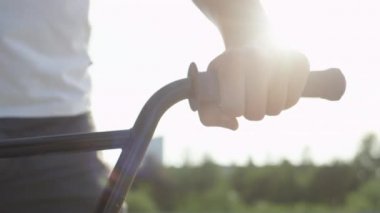 Ağır çekim Dof aşırı yakından: Ayrıntılarını bmx bisiklet donanımları, aşırı motorcu eller üzerinde gidon kulpları yerleştirerek. Bisiklet gidon, holding bmx motorcu şehirde binmek için hazırlık arkasında parlayan güneş