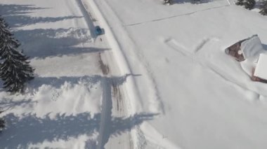 Hava: rüya gibi kayak merkezinde geleneksel Alp dağ evi geçmiş kaygan soğuk sokakta araba turkuaz spor araba. Dağ Vadisi ve büyük kozalaklı orman güzel güneşli kış gününde