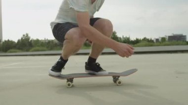 Ağır çekim yakın çekim: kaykay ve flip atlama tanınmaz kaykaycı ollie hüner beton sokak üstünde. Aşırı closeup kaykaycı'nın ayakları atlama kaykay ile hüner şehirde fiske vurmak