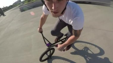 Portre yakın çekim: sürme ve atlama bunny hop hileler güneşli Park Yaz aylarında aşırı bmx motorcu duvar. Hile ve duvar Ollie yapıyor serin genç bmx motorcu Şehir Parkı güneşli günde sürmek.