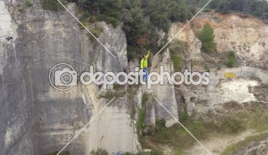 Hava, yakın: aşırı highliner terk edilmiş ocağında kayalık duvarlar arasında gerilmiş uzun highline yürüyüş yukarıda uçan. Genç adam slacklining ile emniyet kemeri, dengesini kaybederek ve düşmeye devam ediyor